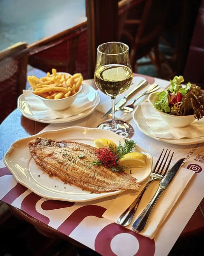 Poisson grillé avec frites et vin, servi en salle au Restaurant Aéro